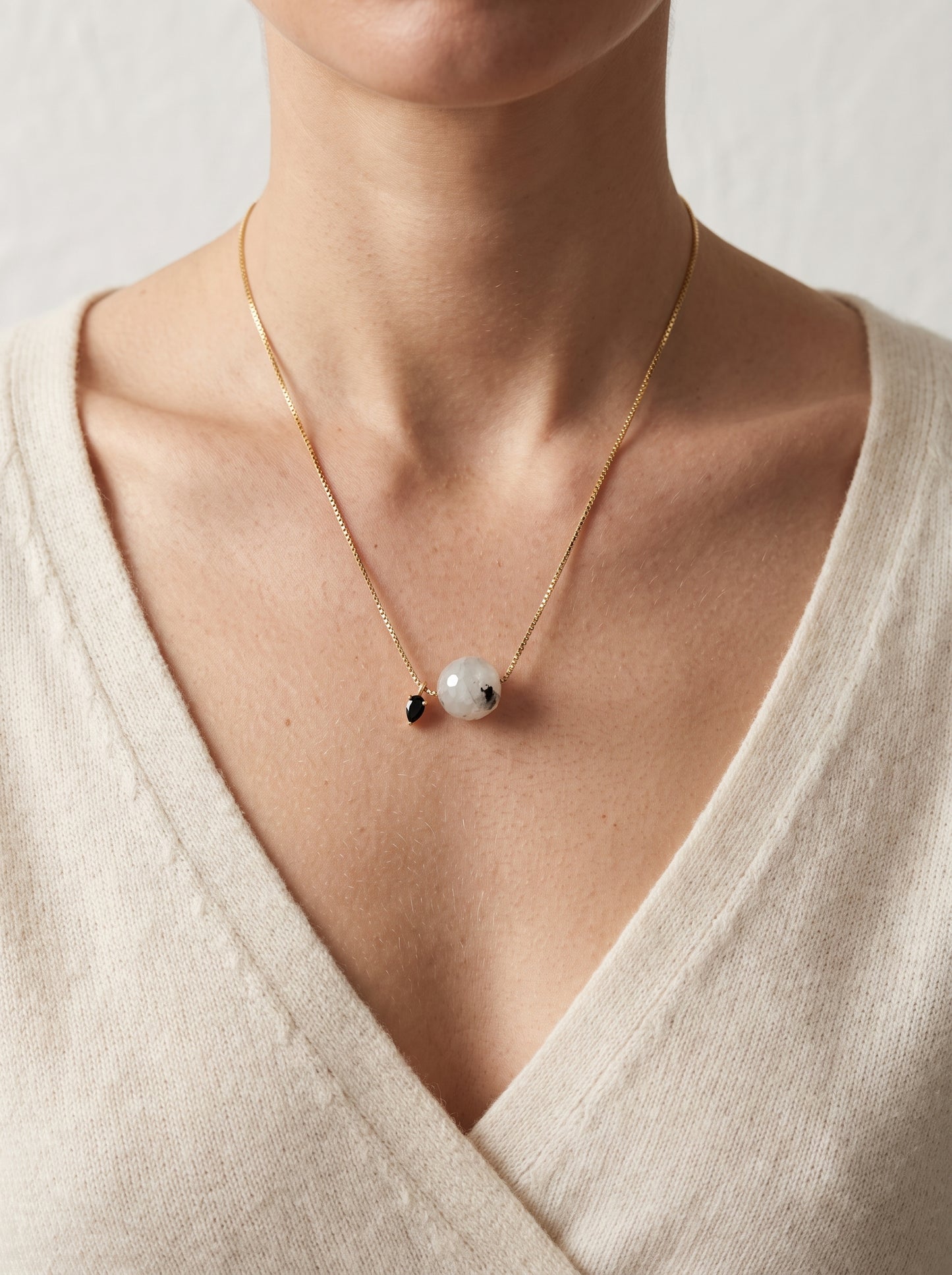 StoneCraft Jewellery - Black rutile quartz slide necklace on model wearing cream jumper, close-up front view