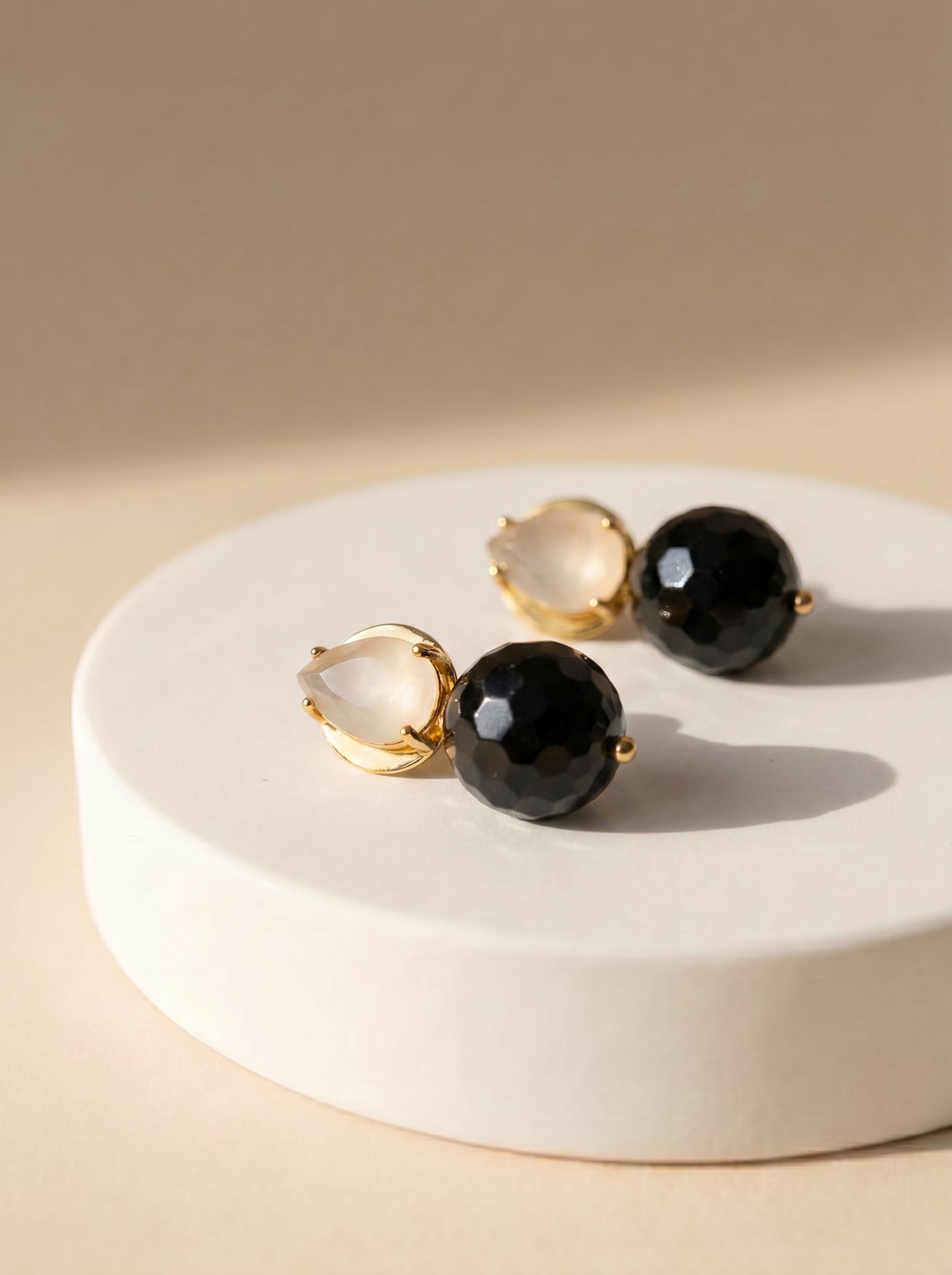 White quartz and black onyx drop earrings flat lay styling shot