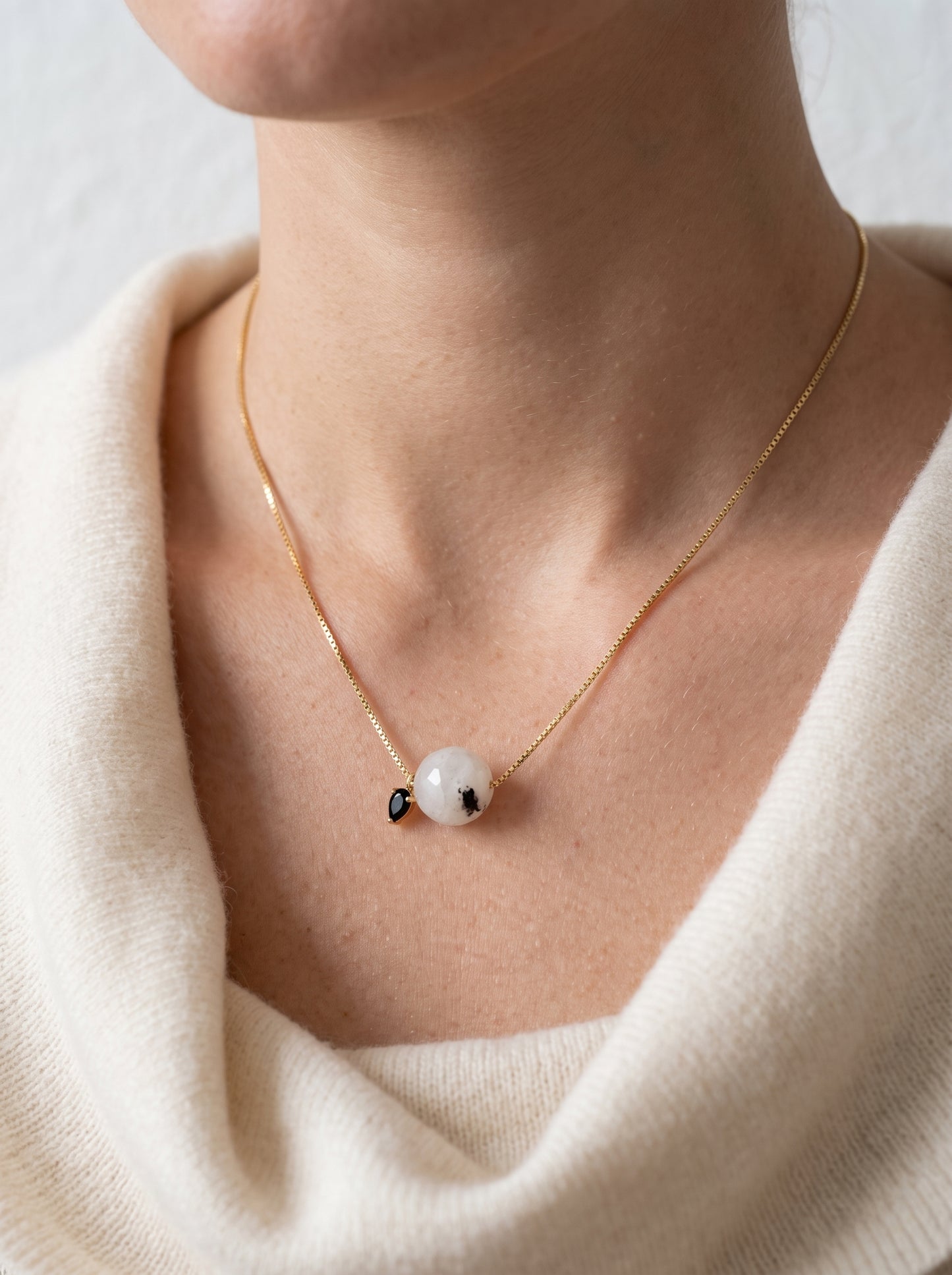 StoneCraft Jewellery - Black rutile quartz bead necklace on model in cream v-neck jumper, front view

