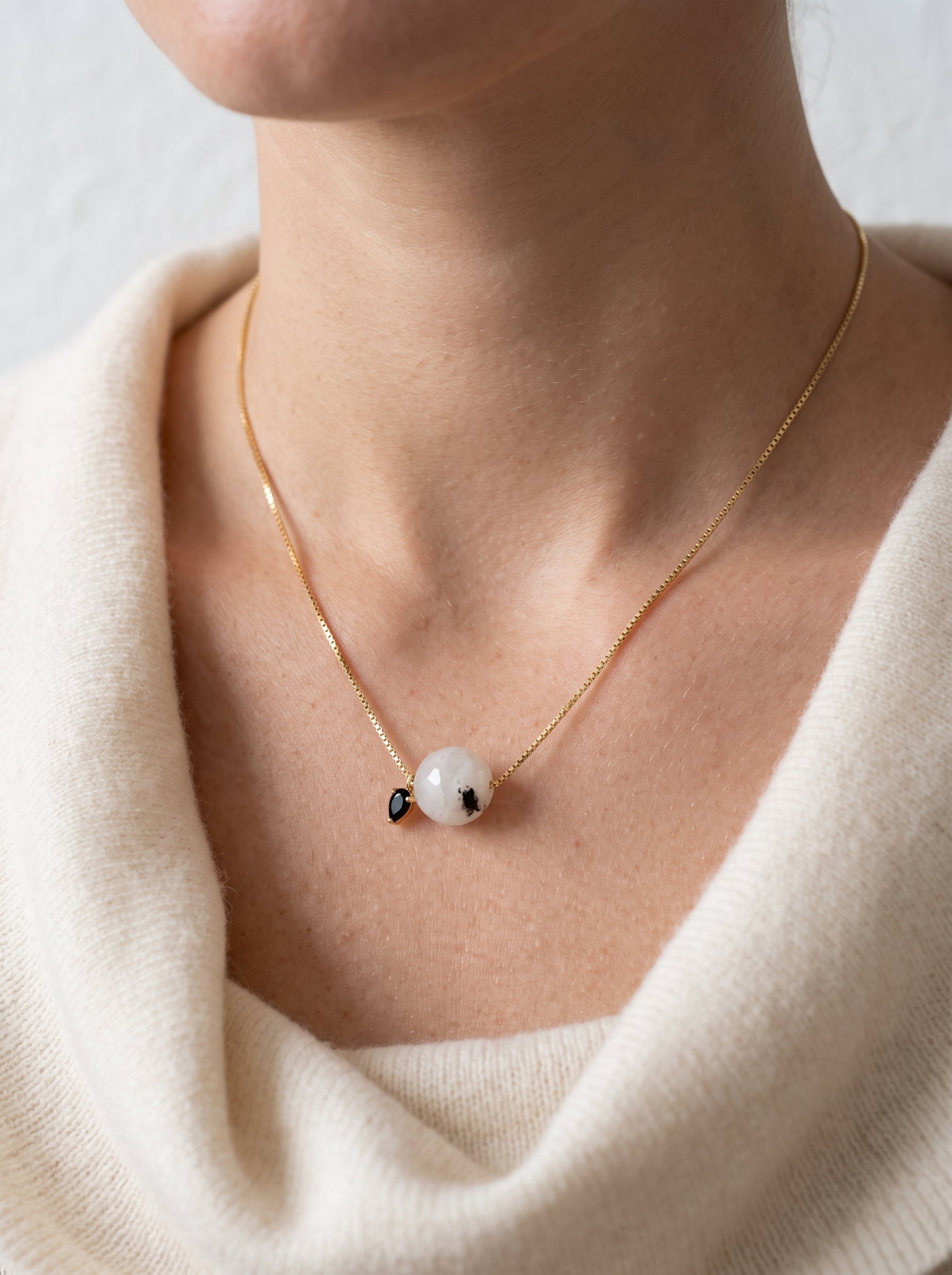 StoneCraft Jewellery - Black rutile quartz bead necklace on model in cream v-neck jumper, front view

