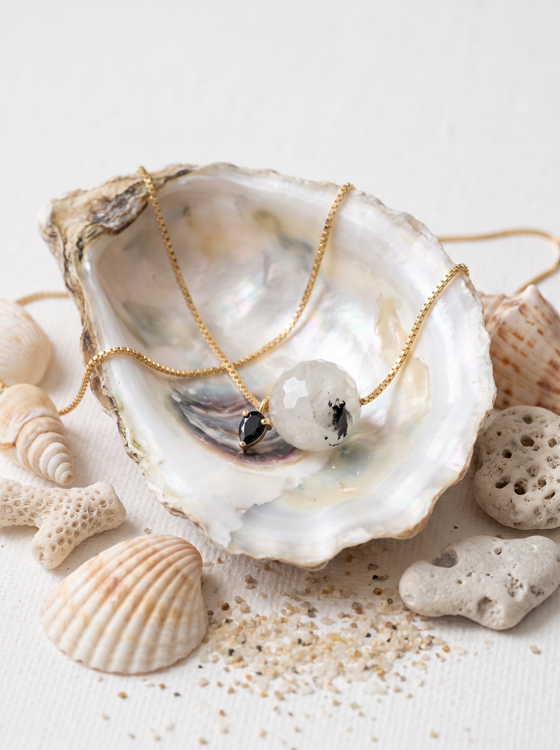 StoneCraft Jewellery - Black rutile gemstone slide necklace displayed in an oyster shell with seashells

