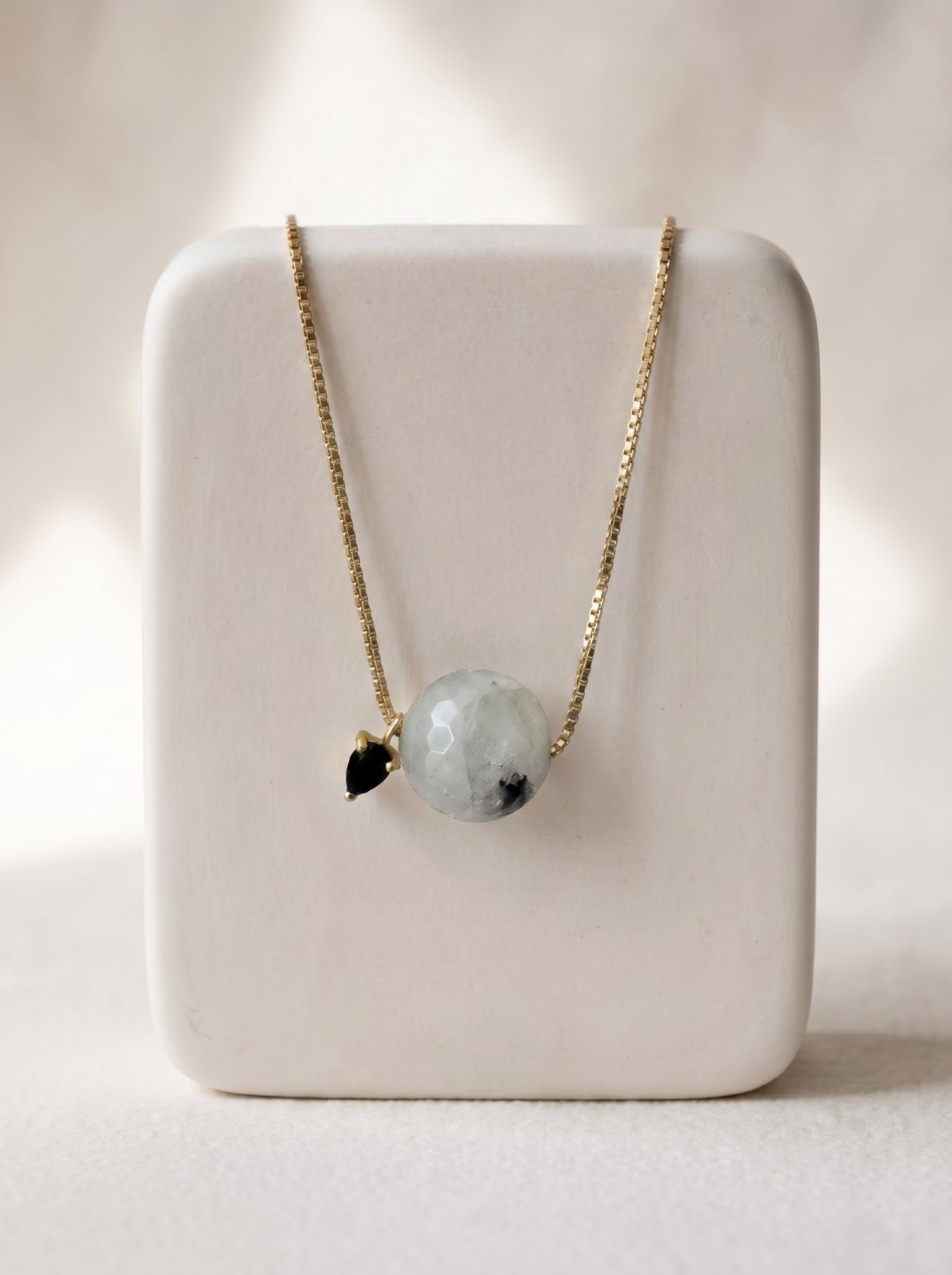 StoneCraft Jewellery - Black rutile quartz slide necklace on a white ceramic jewellery stand