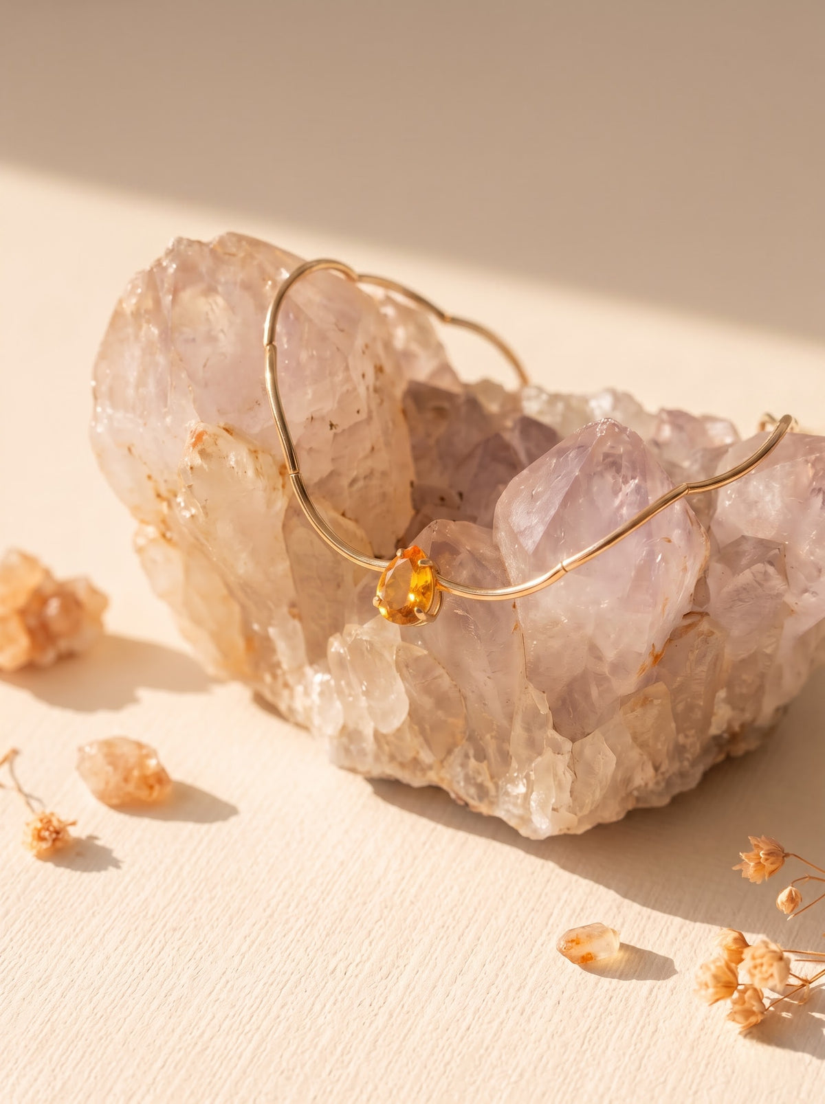 StoneCraft Jewellery Gold Wave Chain Necklace with orange Crystal Pendant displayed on rose quartz crystal with dried flowers
