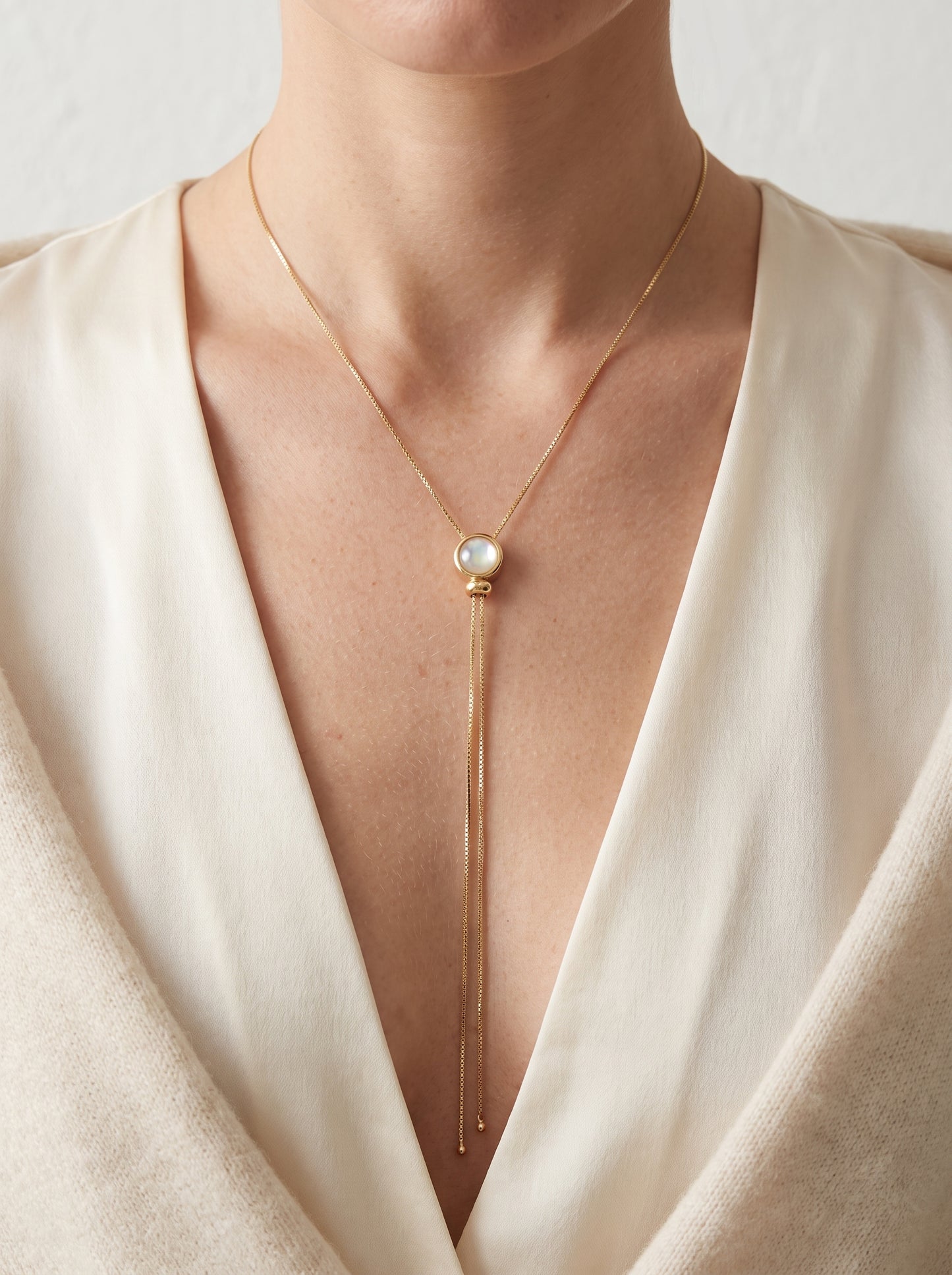 Opalite Lariat Slide Necklace gold-plated worn on model in cream wrap top showing full lariat drop with opalite pendant — StoneCraft Jewellery