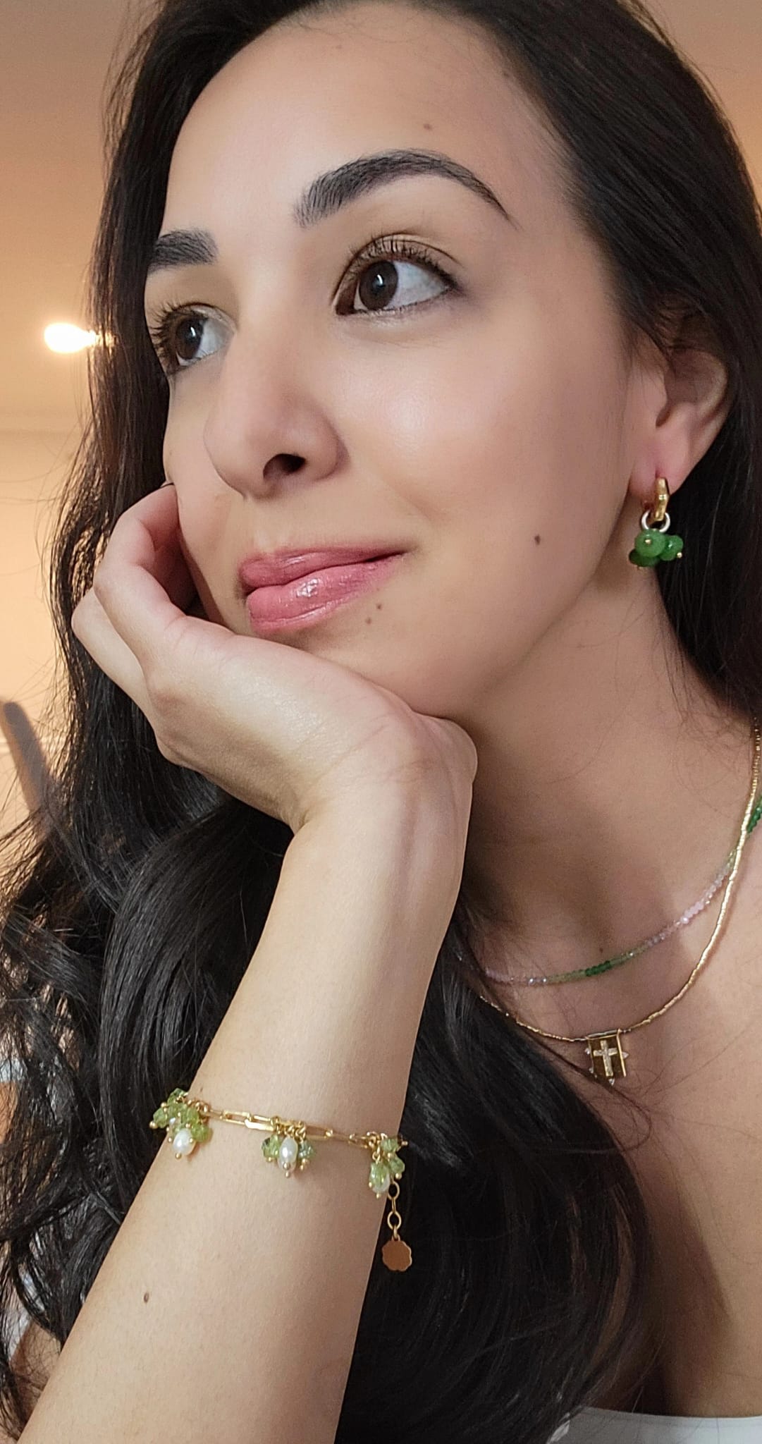 Woman wearing green  agate hoops earrings and bracelet with a neutral background