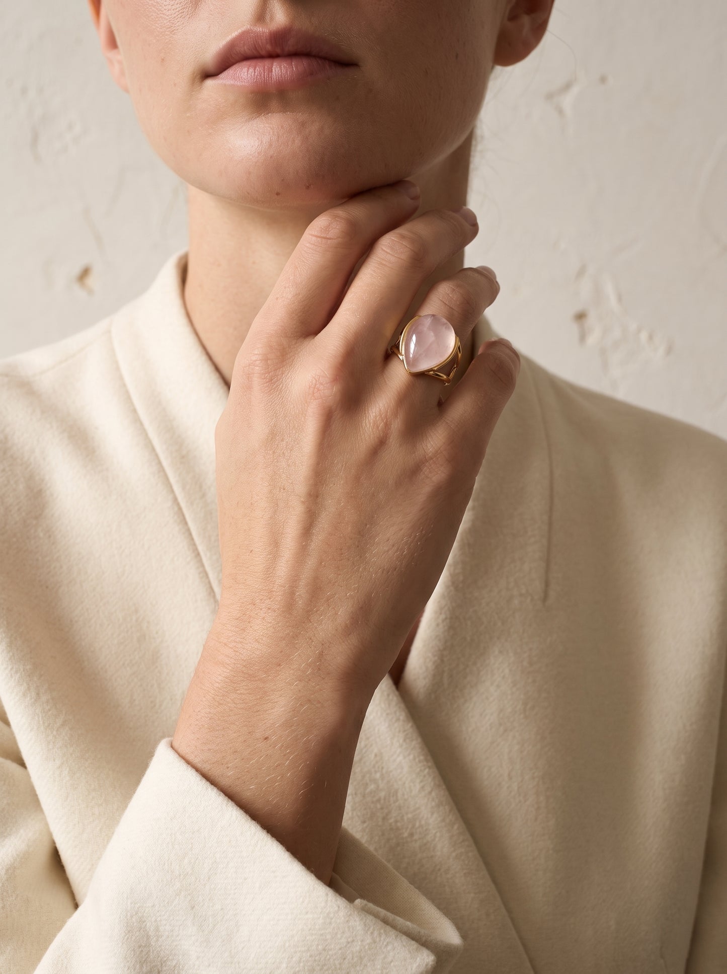 Woman wearing StoneCraft Jewellery rose quartz teardrop gold plated ring close up on hand