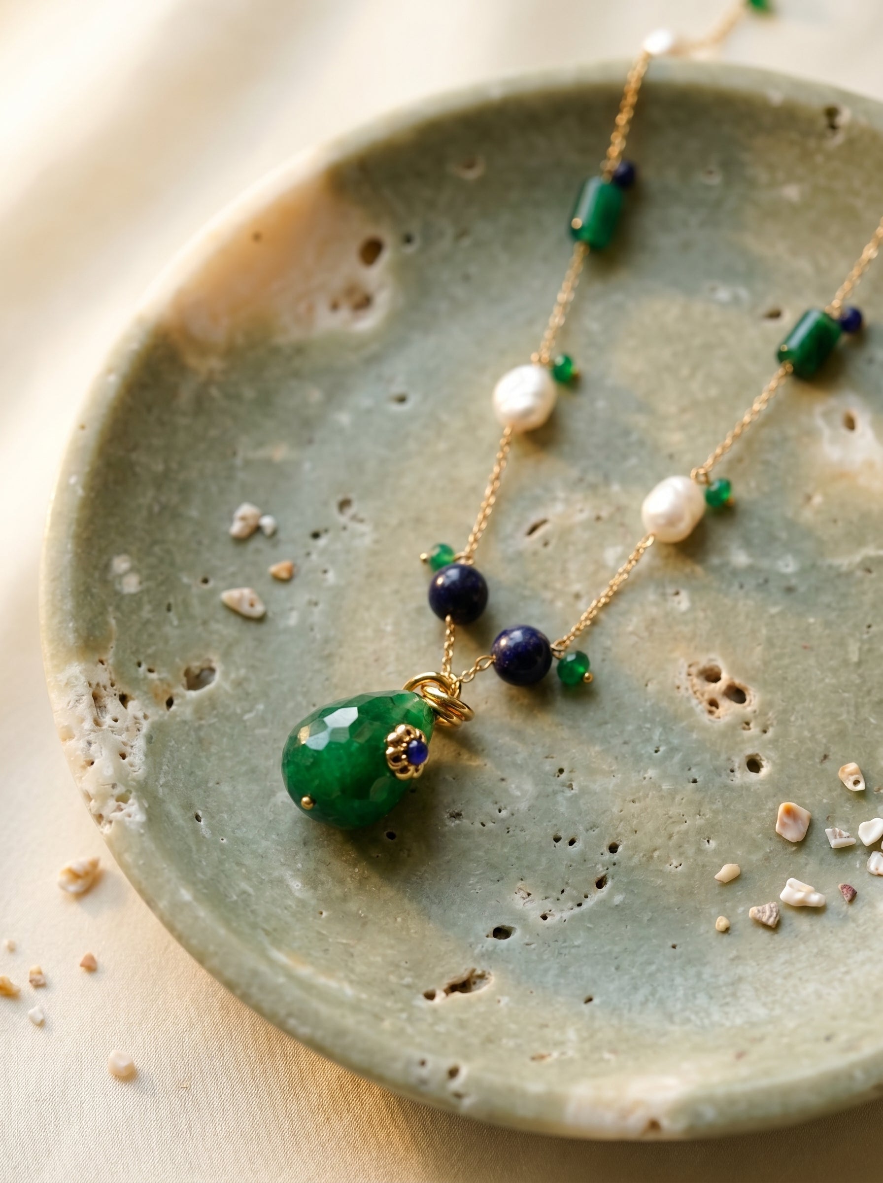 Green jade drop pendant with gold floral cap and sapphire bead detail on gold-plated chain