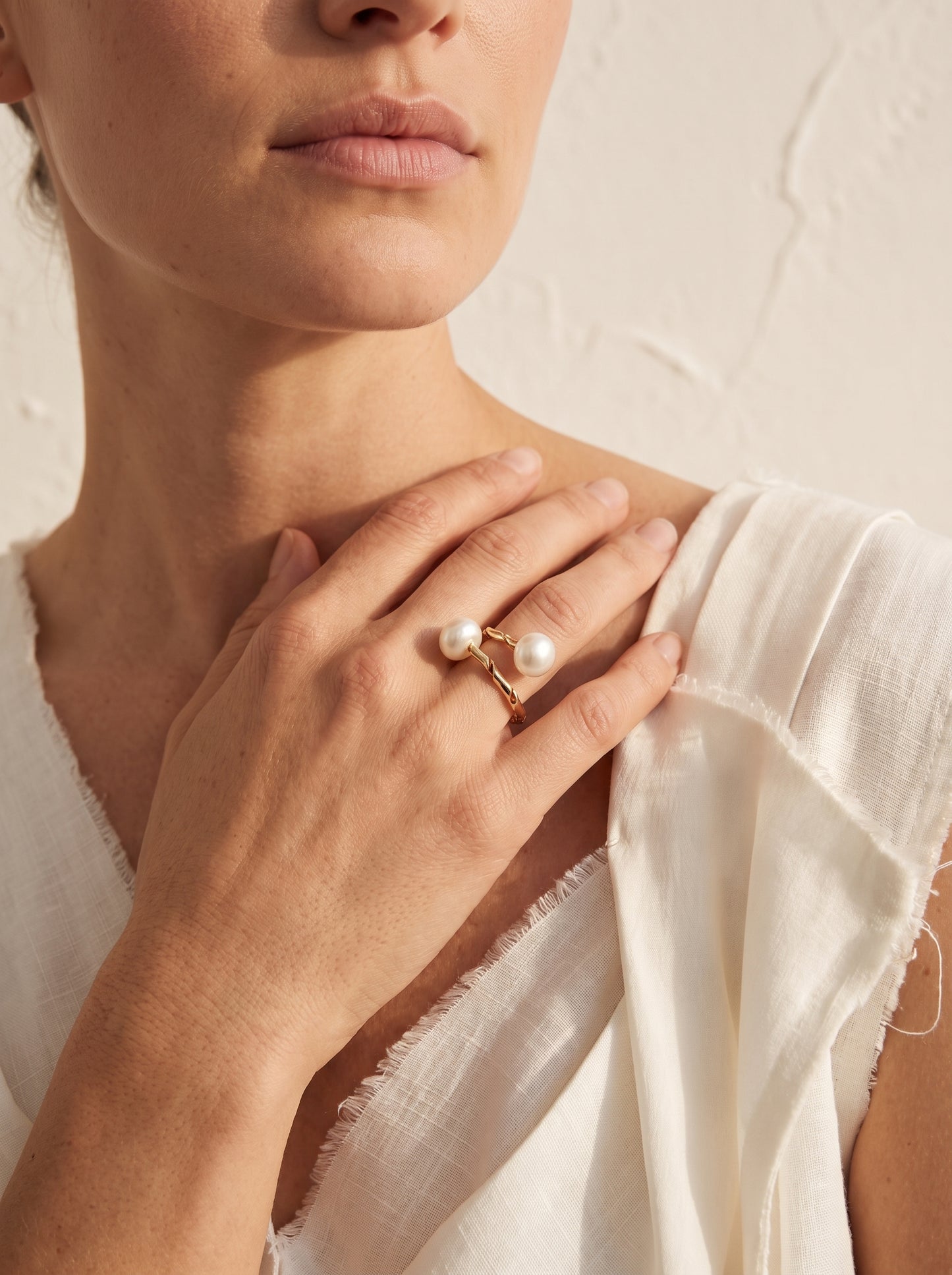 Woman wearing dual pearl twisted gold ring on hand