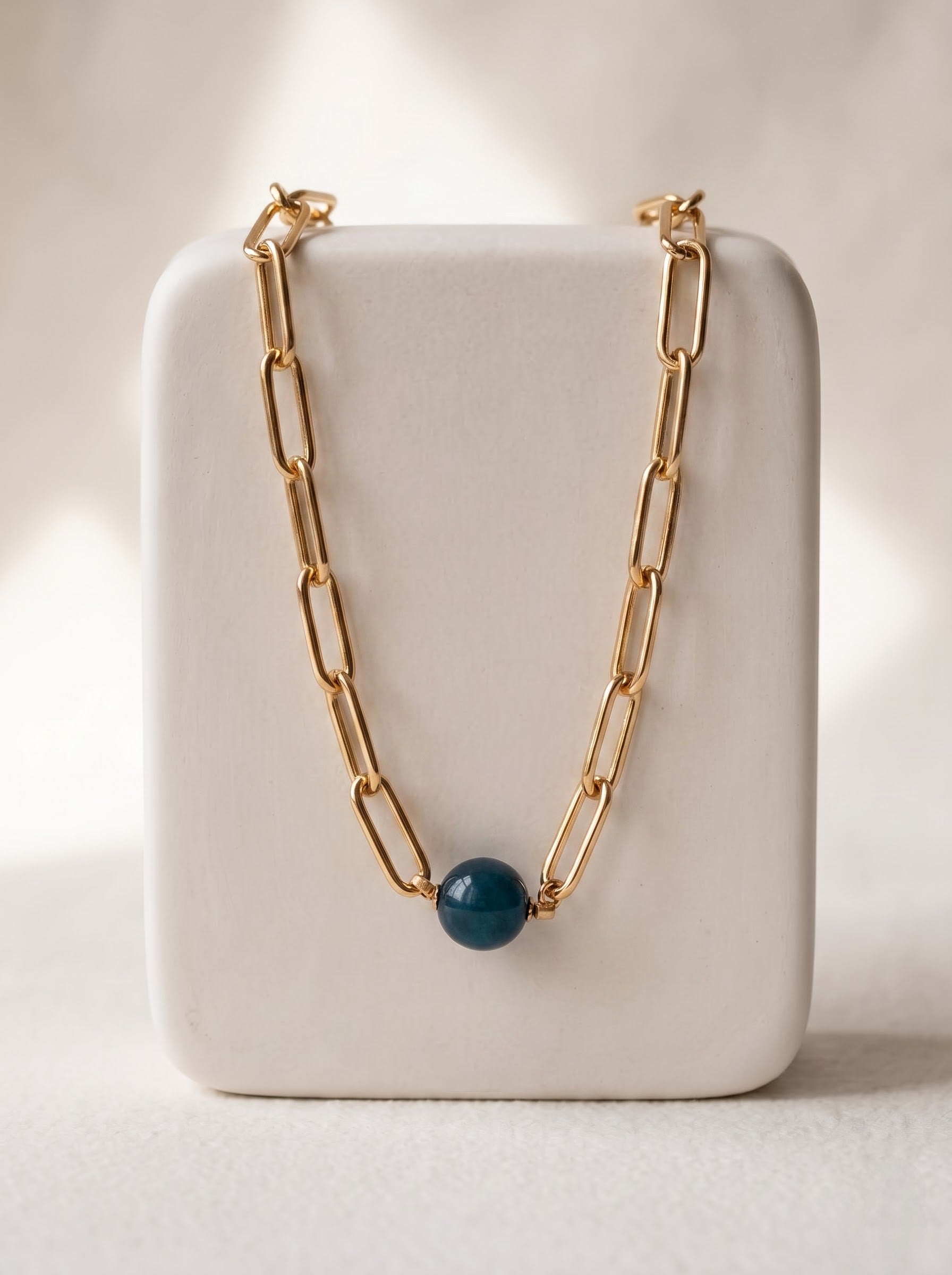 StoneCraft Jewellery apatite gemstone sphere gold paperclip chain necklace, displayed on white ceramic jewellery stand.