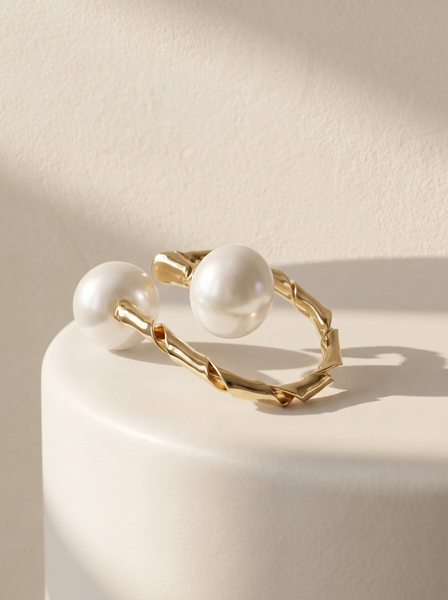 Dual pearl twisted gold ring side view on white surface