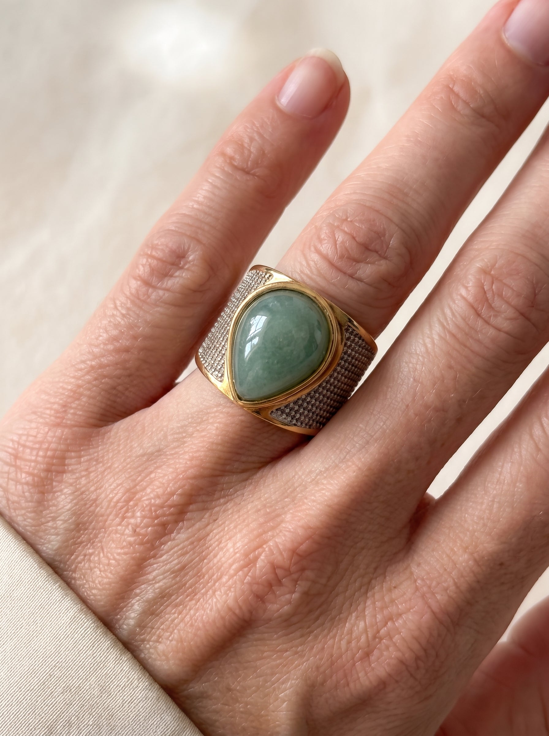 Woman wearing StoneCraft Jewellery green quartz teardrop wide band ring gold white rhodium plated close up on hand