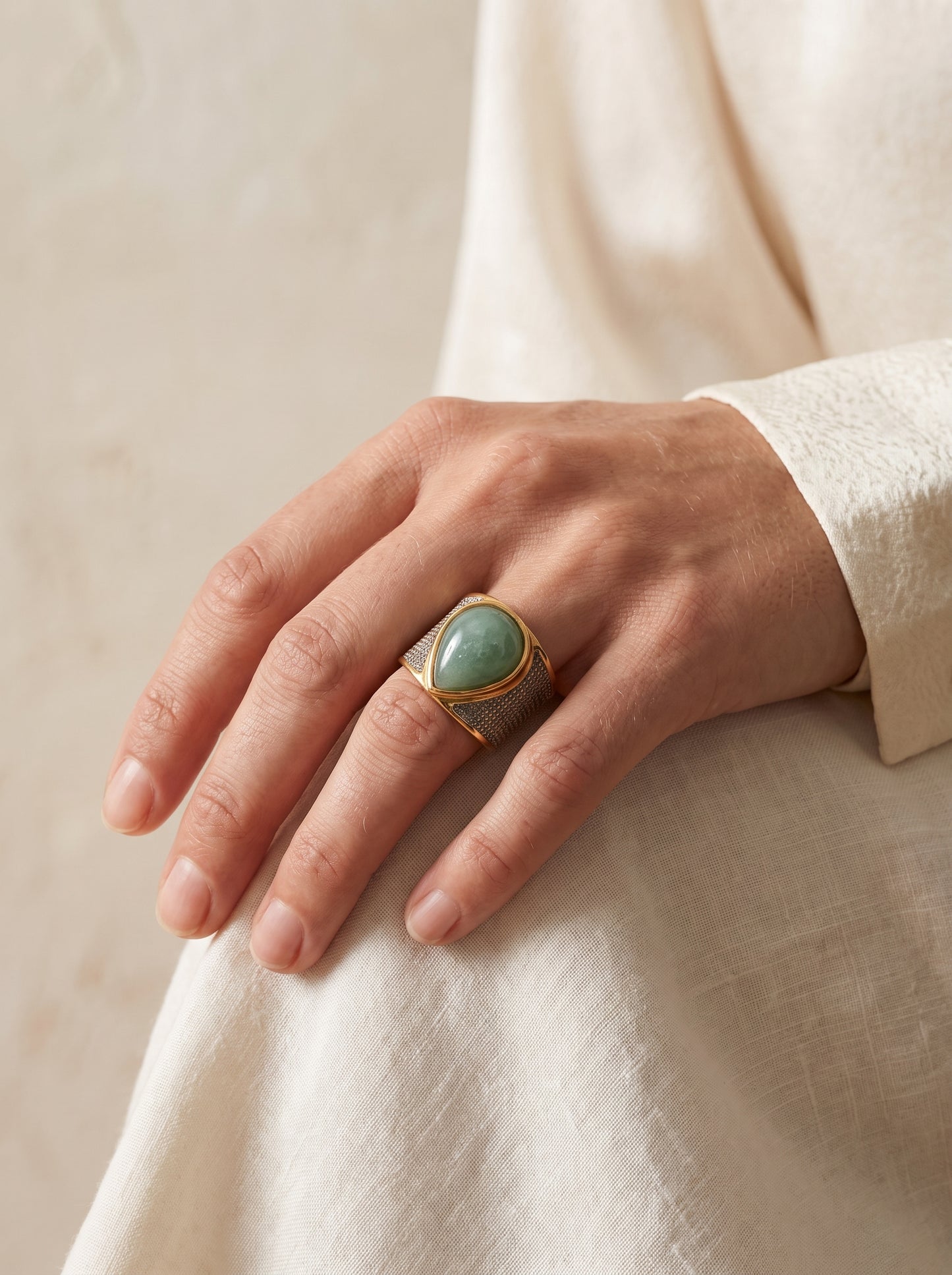 Woman wearing StoneCraft Jewellery green quartz teardrop wide band ring gold white rhodium plated on hand side view