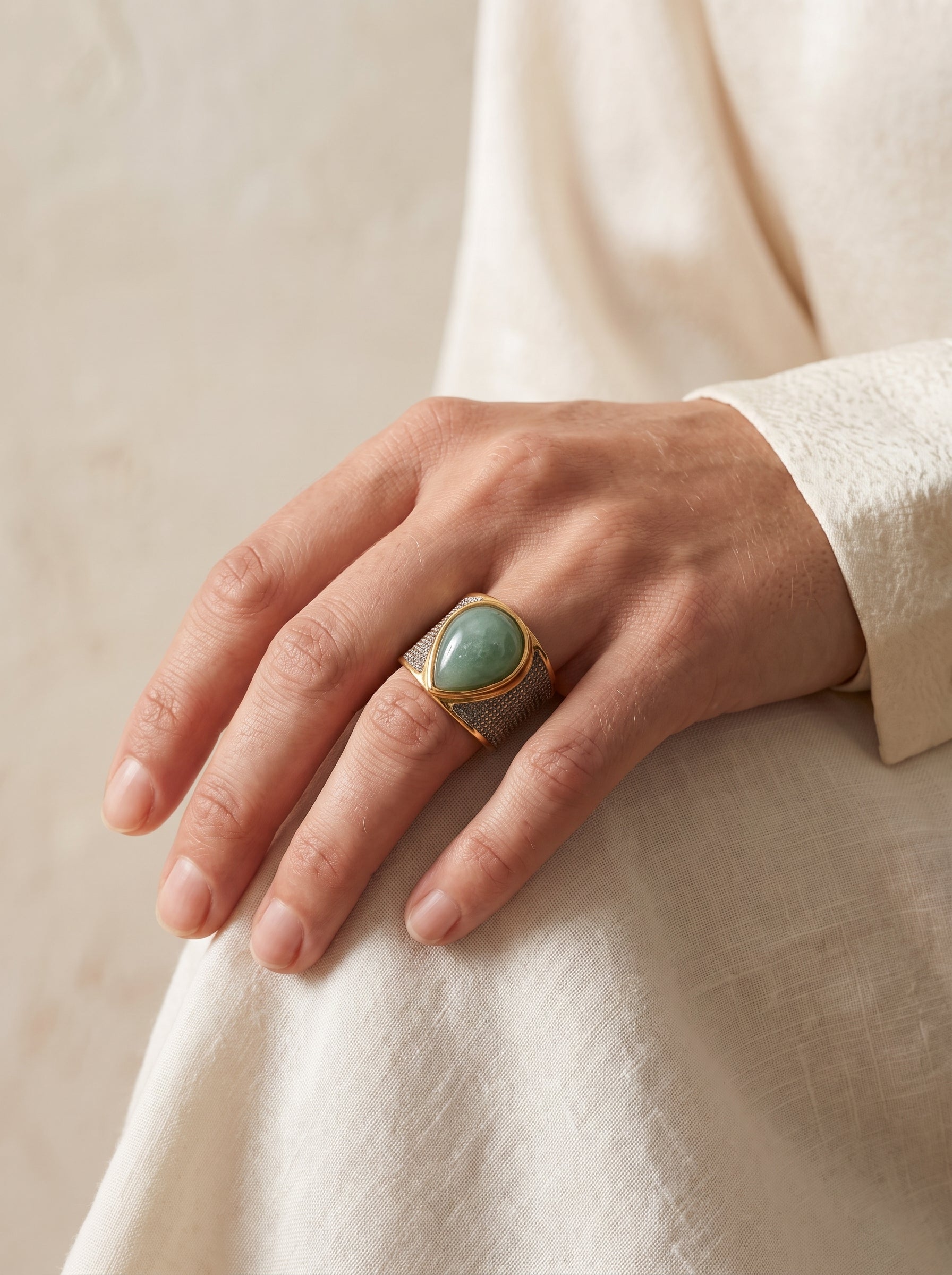 Woman wearing StoneCraft Jewellery green quartz teardrop wide band ring gold white rhodium plated on hand side view