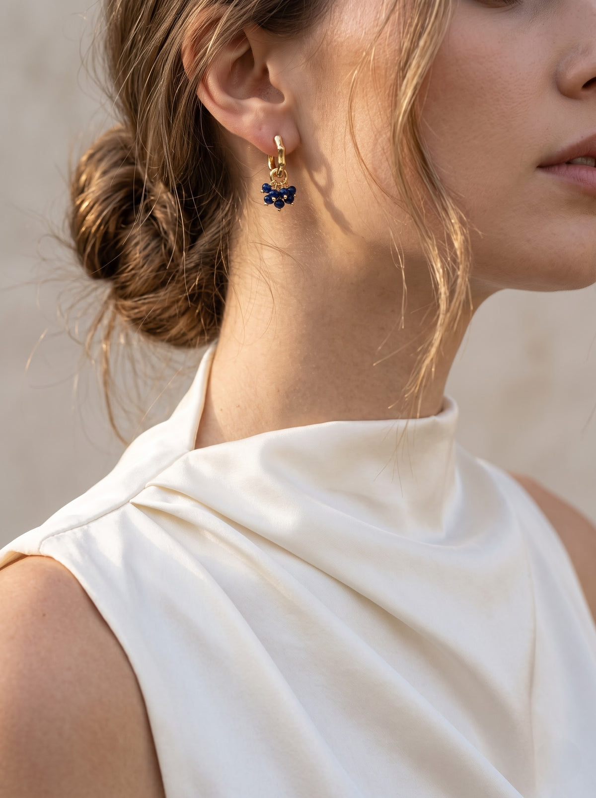 Close-up of gold-plated hoop earring with lapis lazuli bead cluster against a neutral background, StoneCraft Jewellery