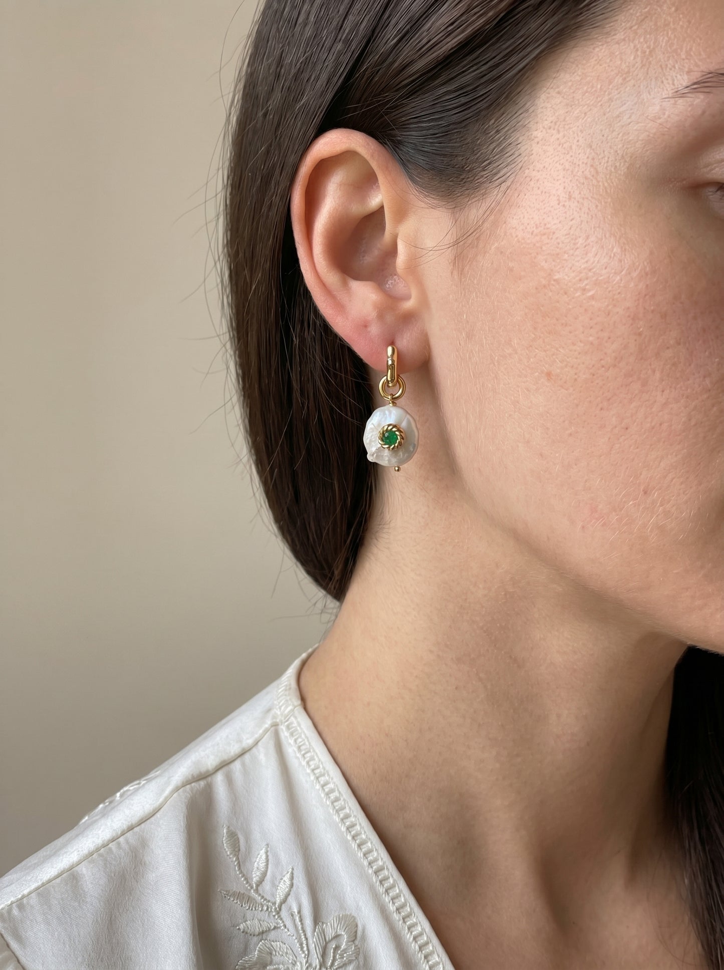 Close-up of detachable Biwa freshwater pearl and green jade charm on gold-plated wave hoop earring
