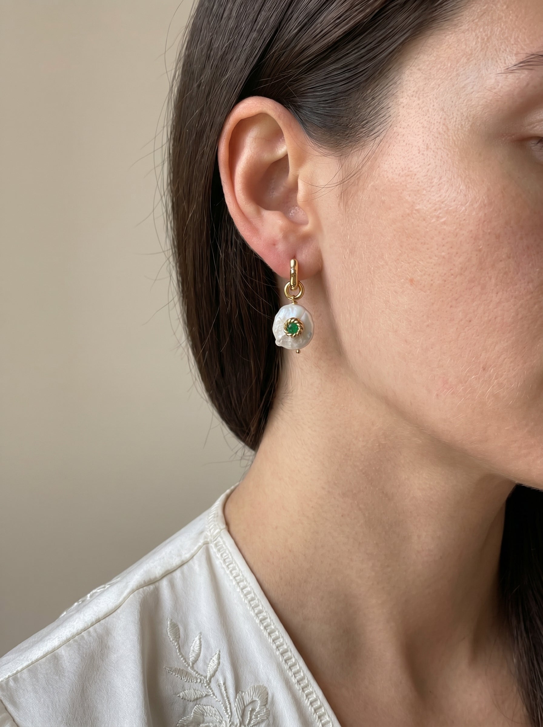 Close-up of detachable Biwa freshwater pearl and green jade charm on gold-plated wave hoop earring