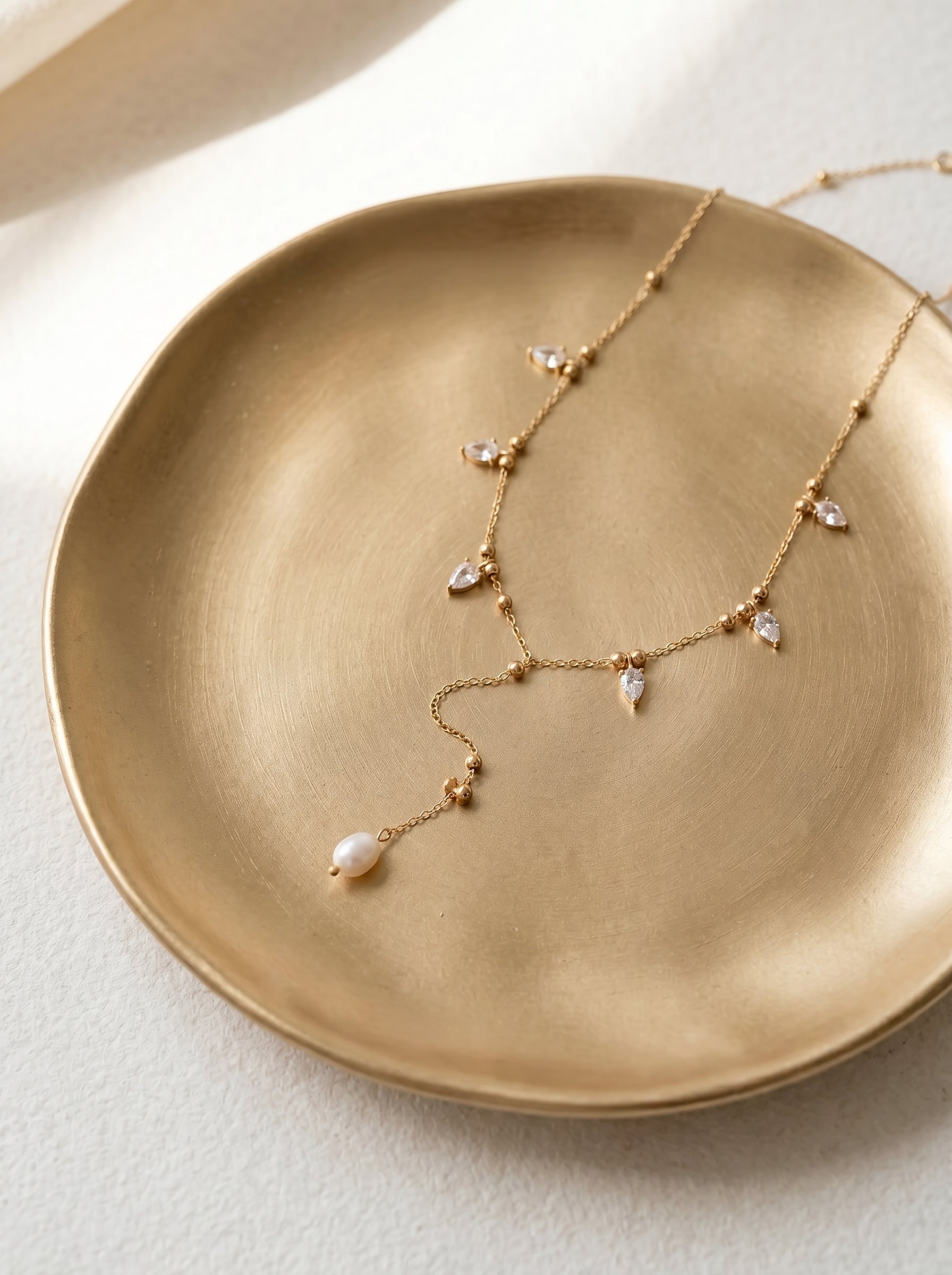 Close-up of baroque freshwater pearl pendant on gold-plated Y-drop lariat necklace