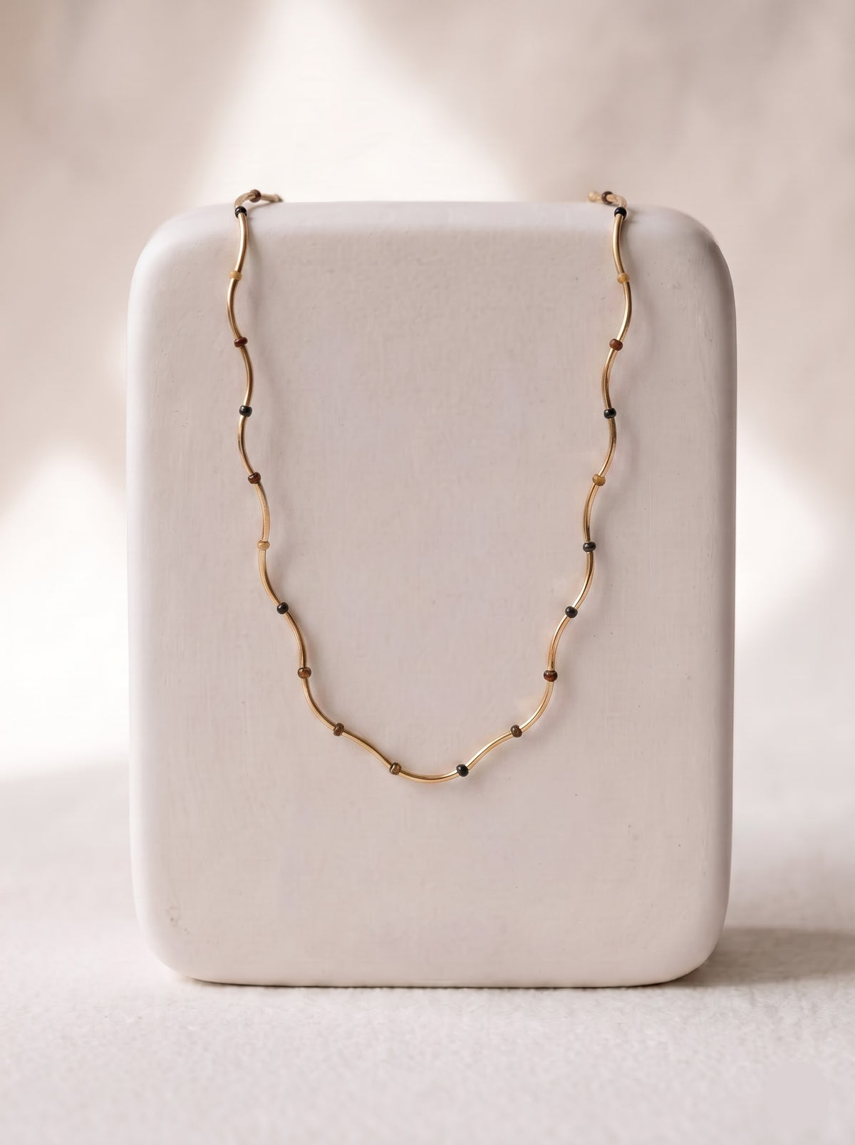 StoneCraft Jewellery Gold Wave Chain Necklace with Tiger's Eye Beads displayed on white jewellery stand