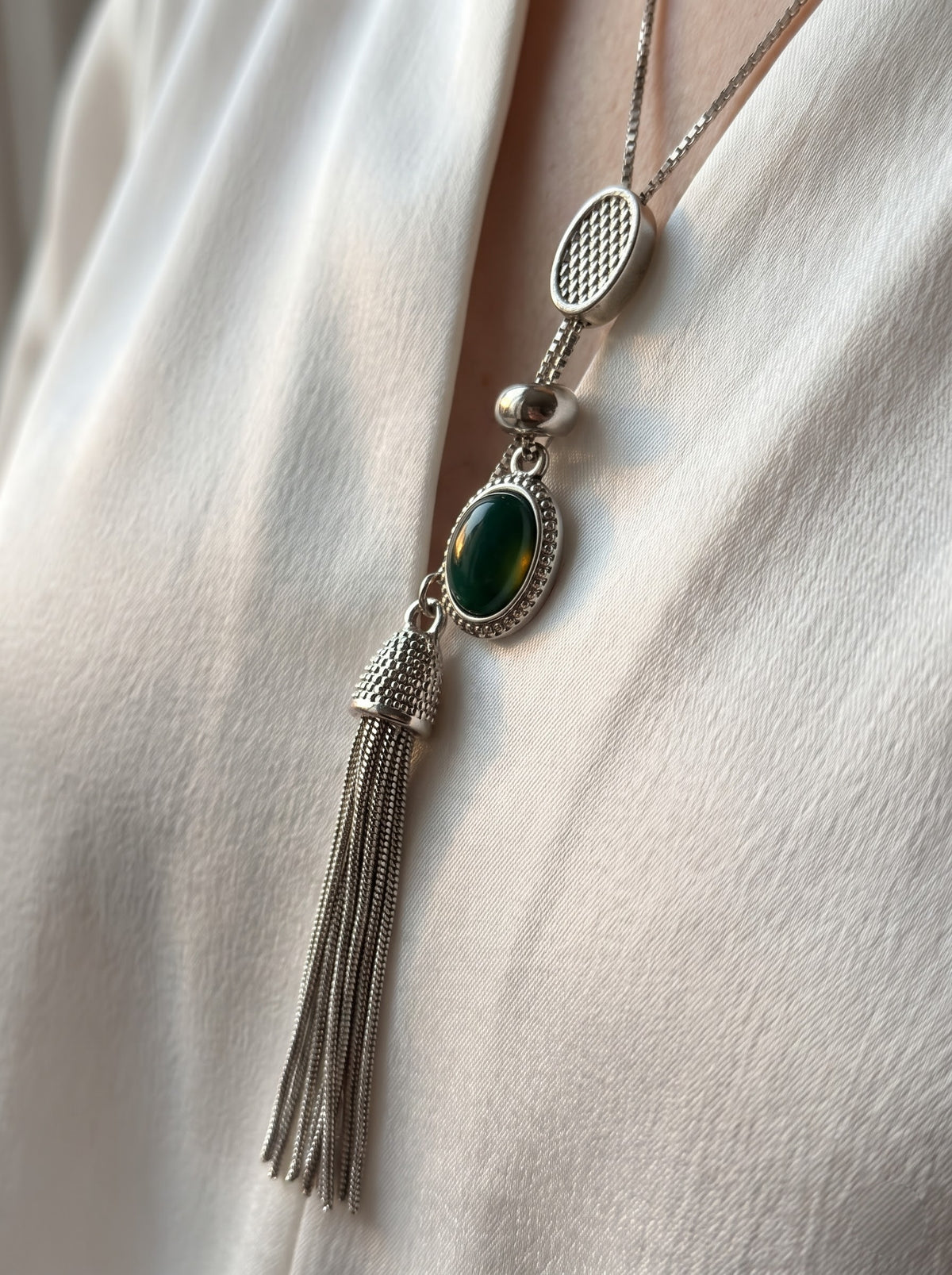 Close-up of StoneCraft Jewellery Green Agate Silver Tassel Lariat Necklace showing green agate cabochon and silver tassel detail
