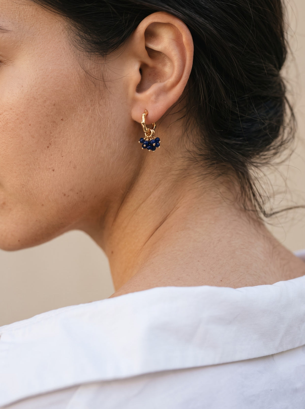 Close-up of gold-plated hoop earrings with lapis lazuli bead clusters, StoneCraft Jewellery