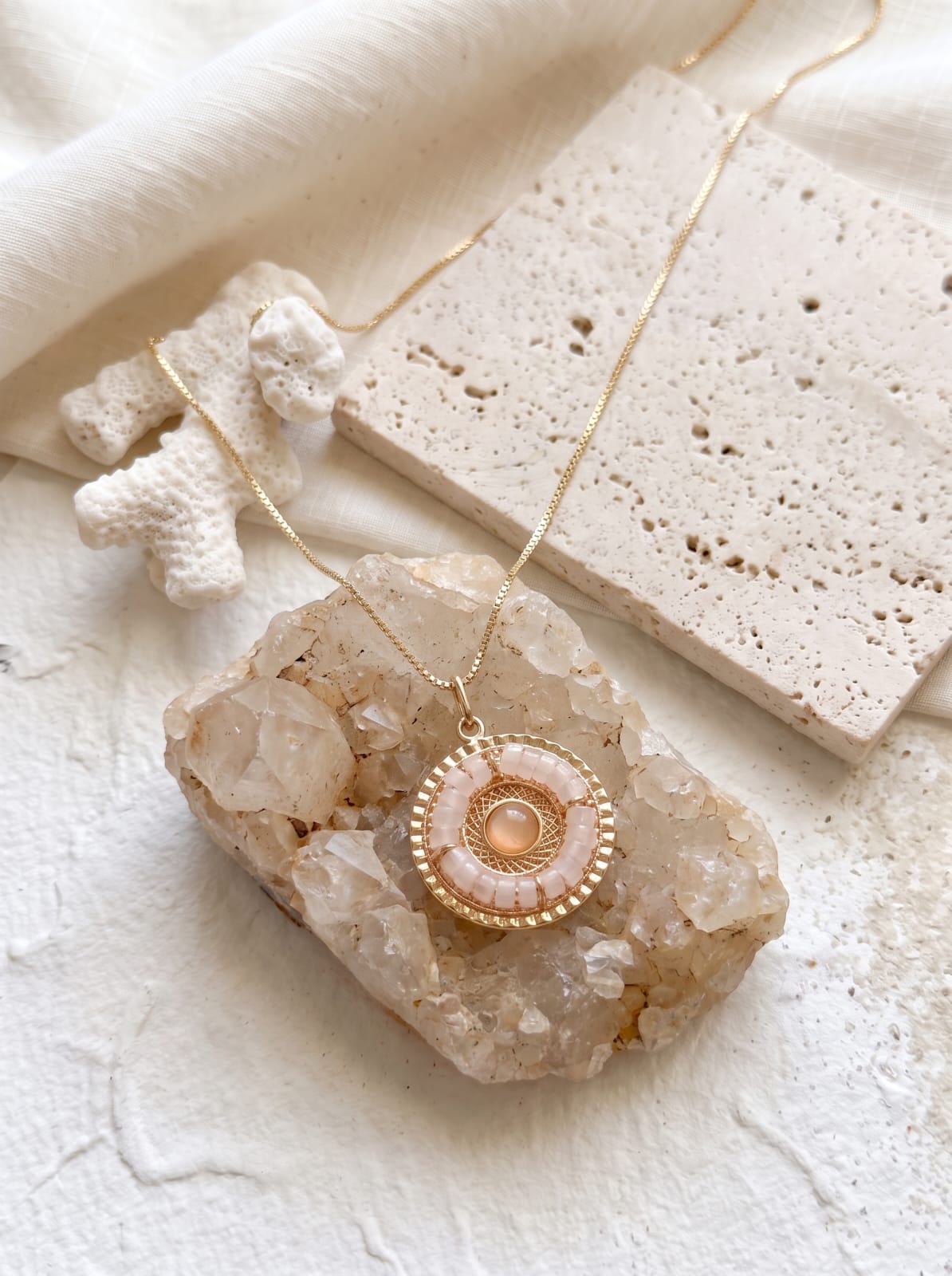 Crystal cluster mandala rose quartz pendant on raw crystal with travertine tiles — StoneCraft Jewellery
