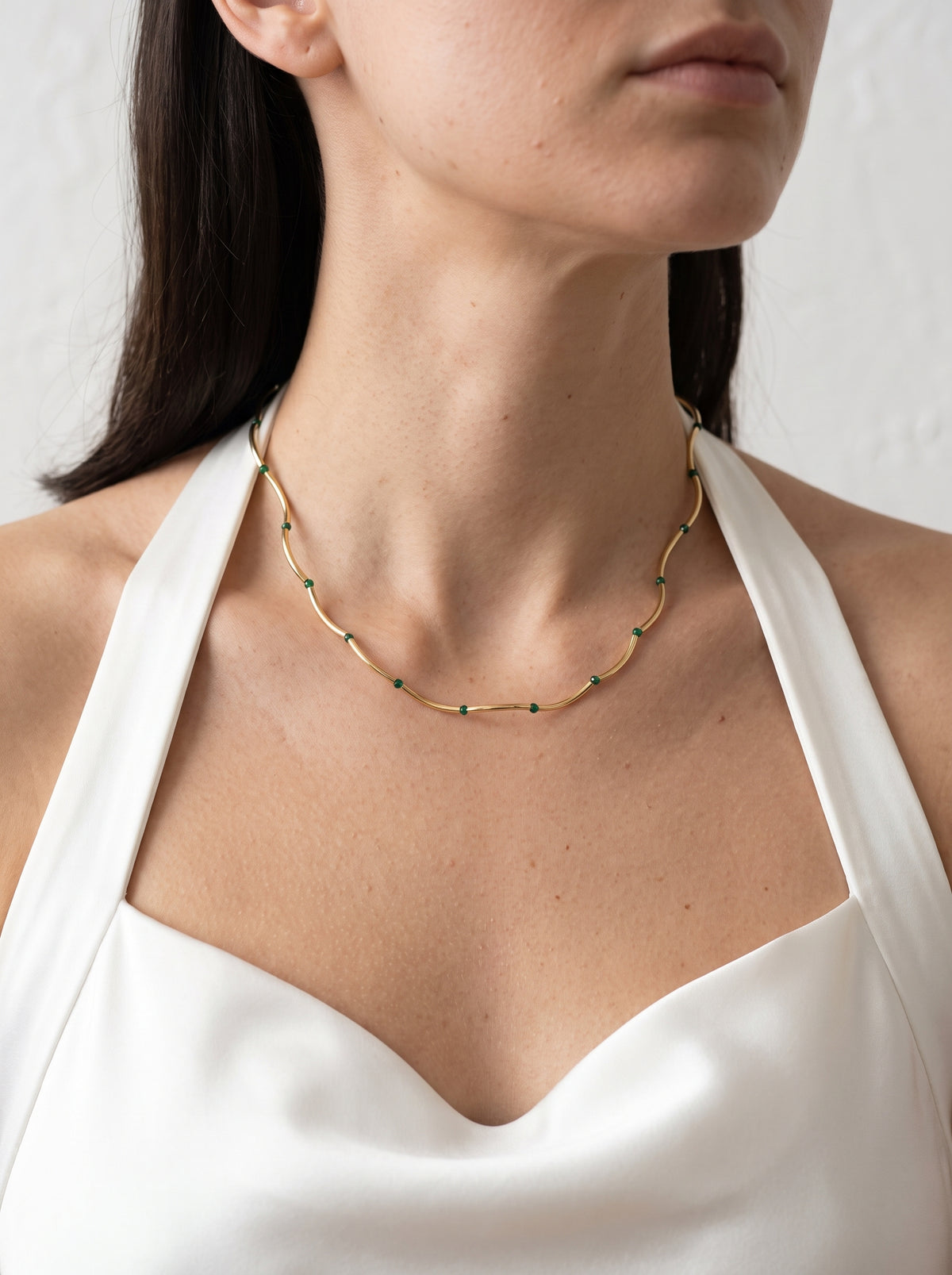 Woman wearing StoneCraft Jewellery Gold Wave Chain Necklace with Malachite Beads full neckline view on white halter top