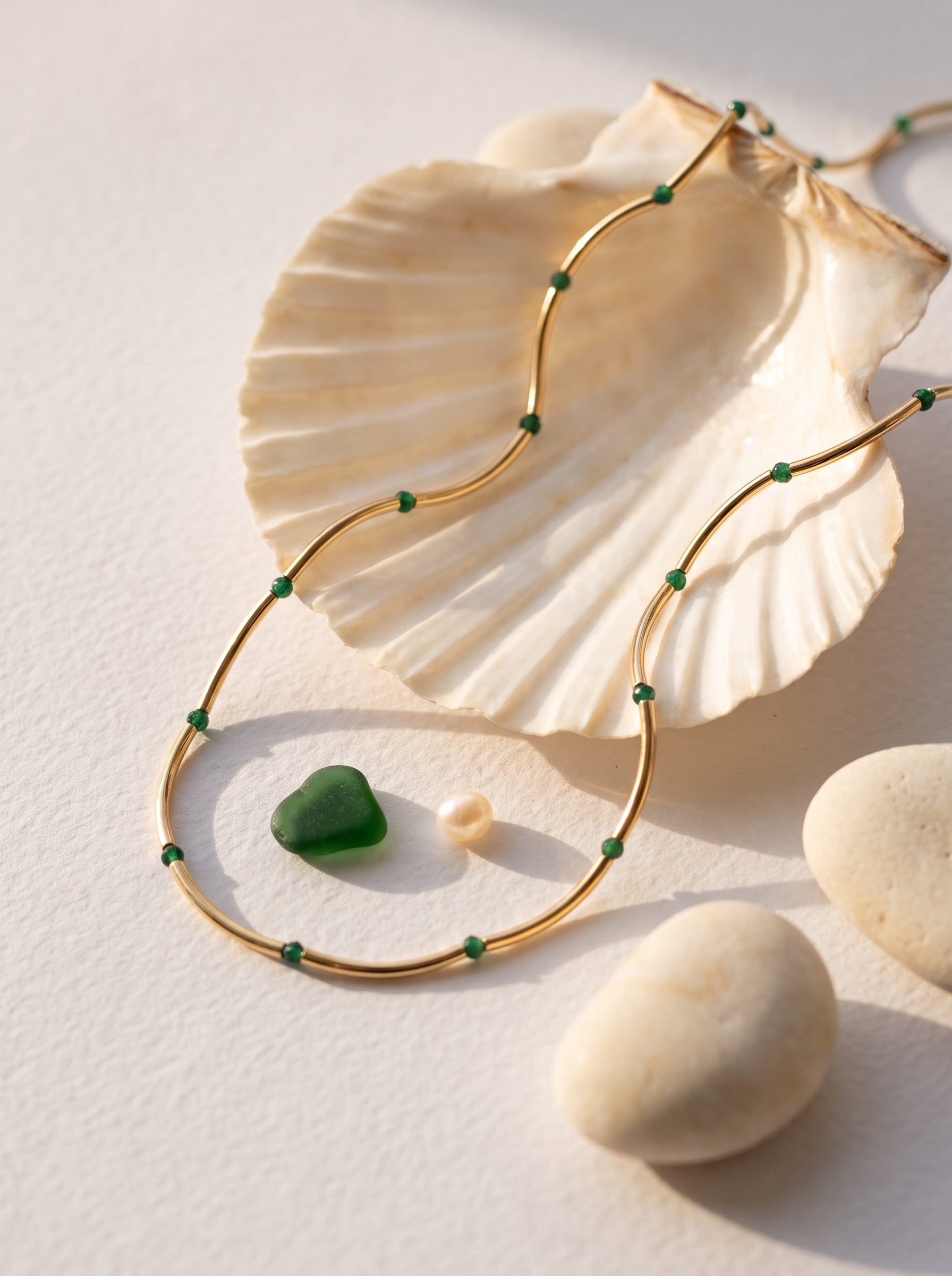 Malachite Bead Chain Necklace gold-plated styled flat lay on seashell with malachite stone and pebbles — StoneCraft Jewellery