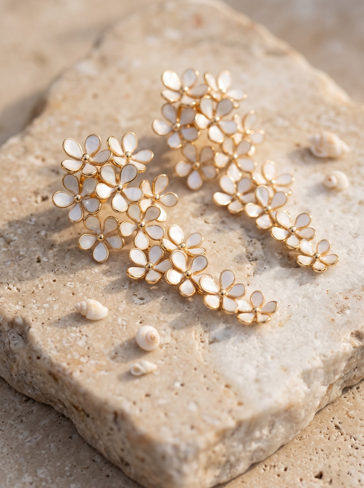 Woman with her hair in a bun wearing a StoneCraft Jewellery white floral cascade earring with gold-plated outlines.