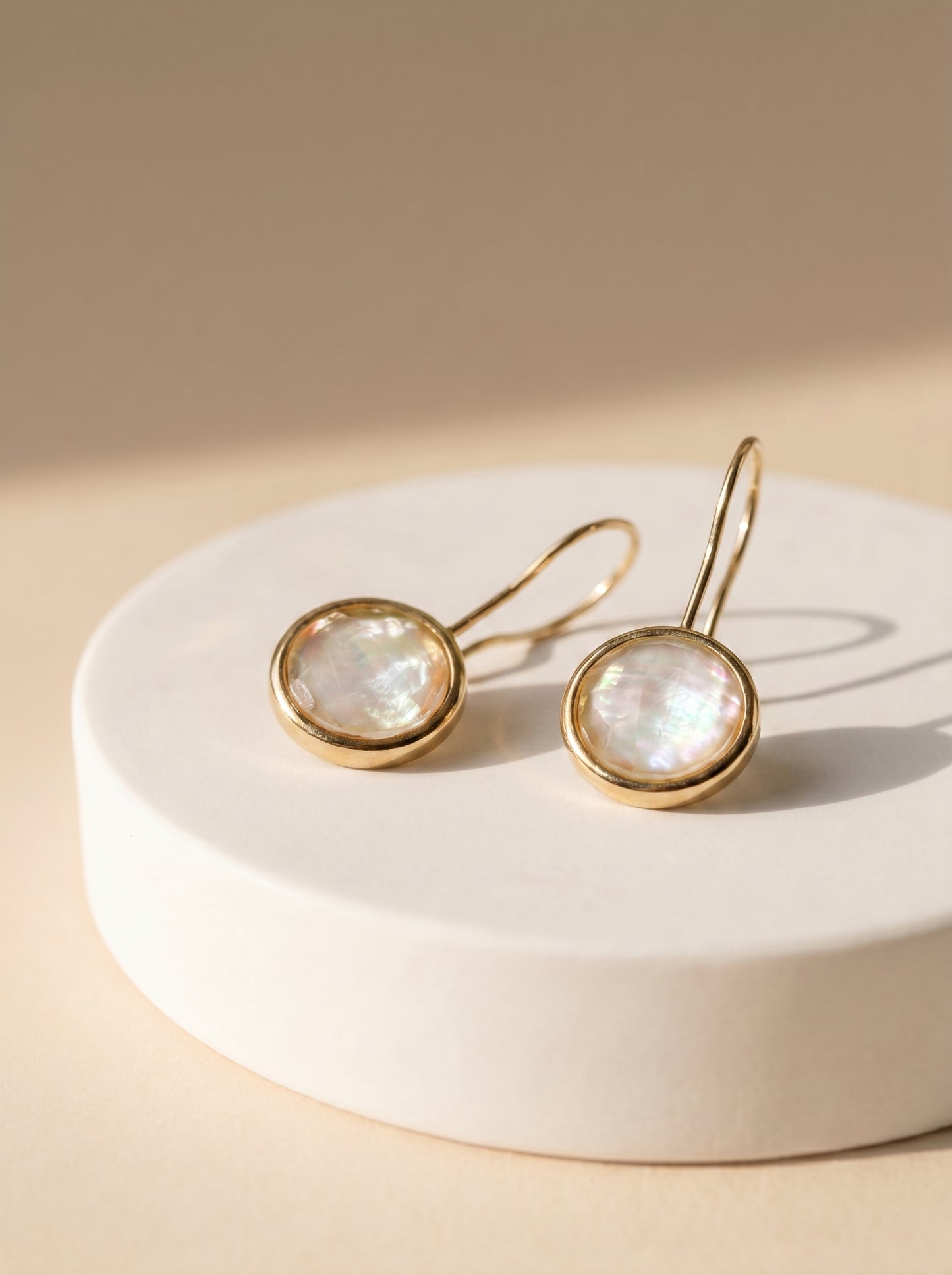 StoneCraft Jewellery Mother-of-Pearl Round Hook Earrings with iridescent white stone in gold-plated setting on white platform