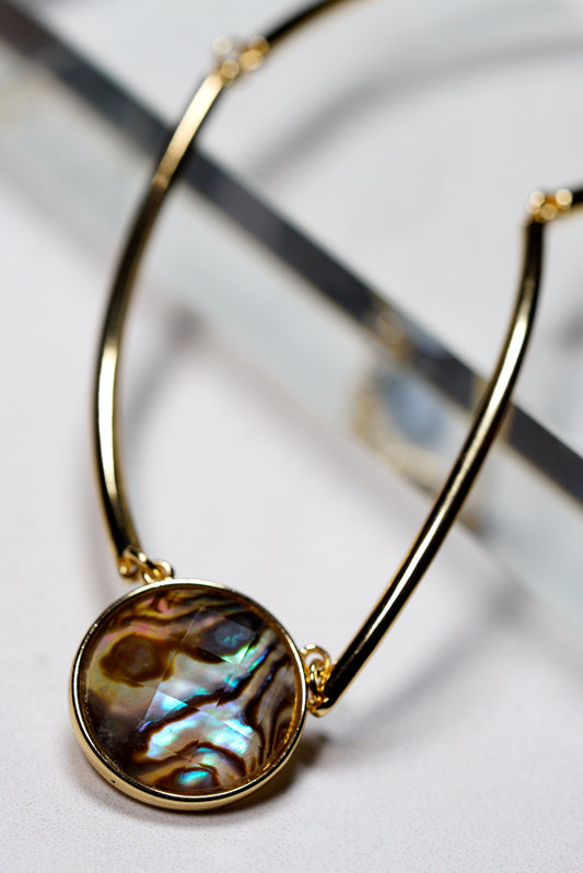 Gold necklace choker with a round, abalone on a white background
