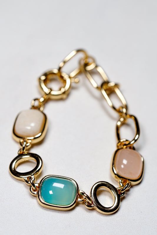 Gold chain bracelet with various gemstones , agate, rose quartz andhematite on a white background