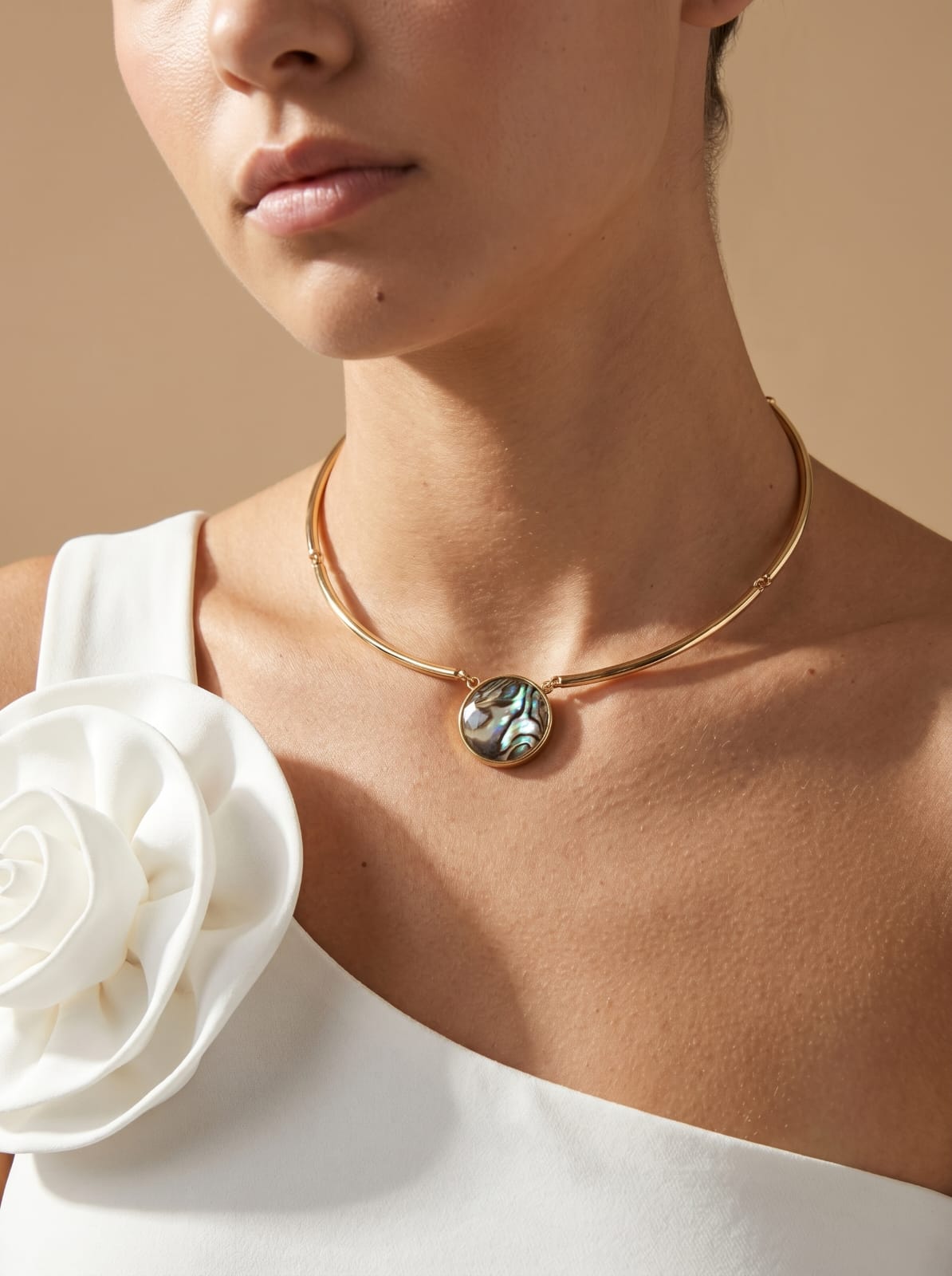 Abalone choker necklace worn at neckline, gold-plated curved bar with adjustable chain